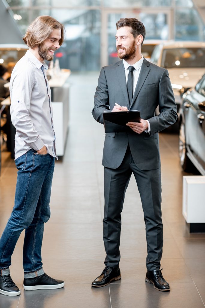 Salesperson with client in the car showroom